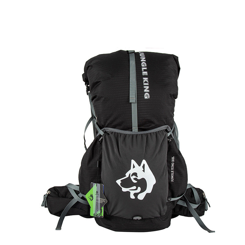 Blackout — Switchback 30L Trail Pack head on, showing the stretch front pocket, a side pocket on each flank and the roll-top closure