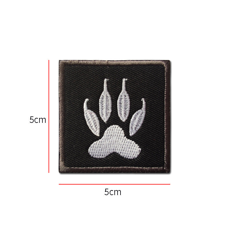 Embroidered white dog claw print patch on black backing, 50 mm square, with hook velcro reverse
