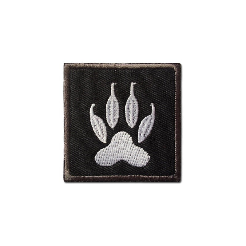 Embroidered white dog claw print patch on black twill backing, shown square-on against a white background