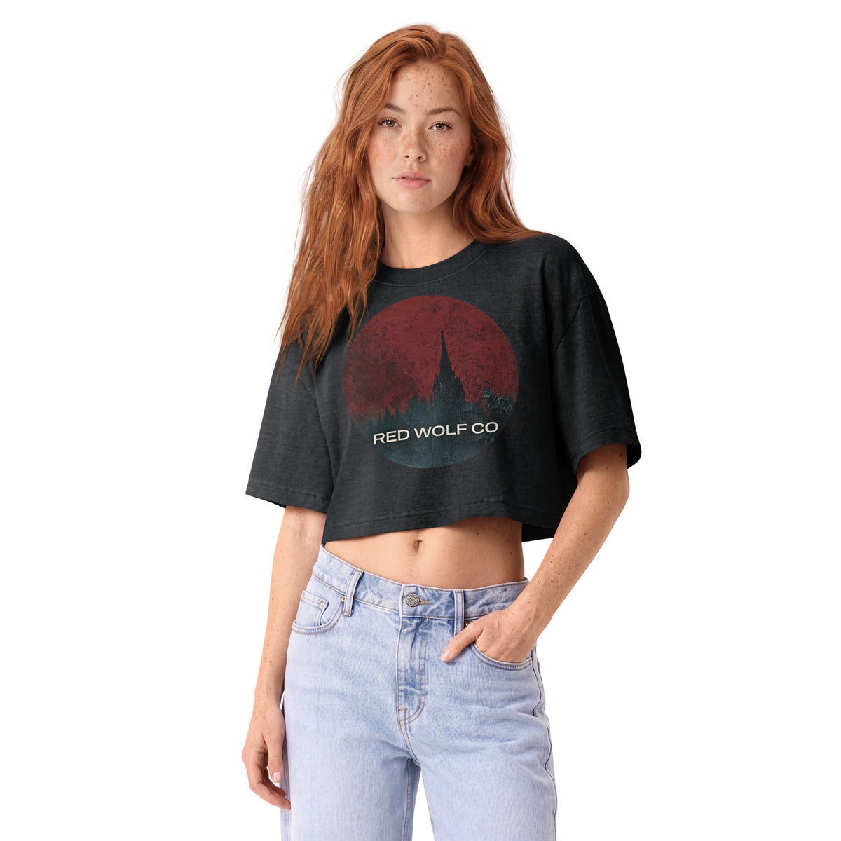 A woman wearing the washed-black Solace Cropped Tee, front view, showing the boxy cropped cut and the Red Wolf Co badge across the chest